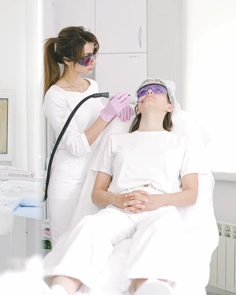 Aesthetician using a facial device in a clinic
