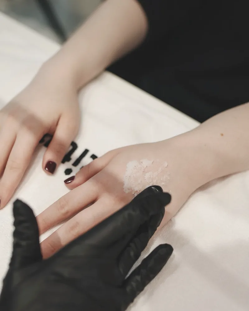 Professional applying a skincare treatment with gloved hands
